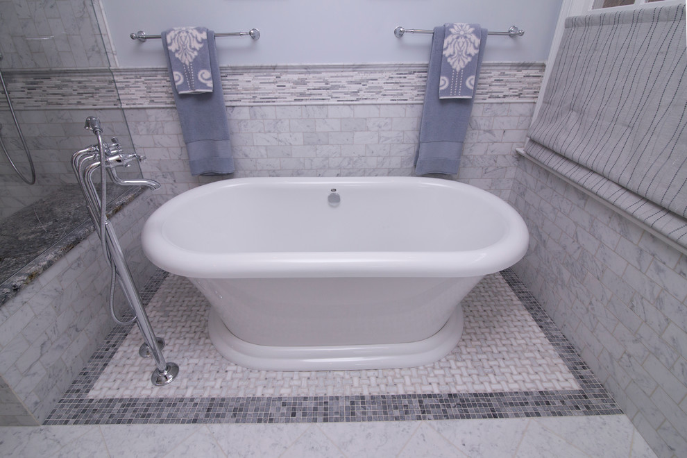 Inredning av ett klassiskt stort blå blått en-suite badrum, med skåp i shakerstil, vita skåp, ett fristående badkar, vit kakel, marmorgolv, ett undermonterad handfat, granitbänkskiva, en dubbeldusch, en toalettstol med separat cisternkåpa, marmorkakel, blå väggar, vitt golv och dusch med gångjärnsdörr