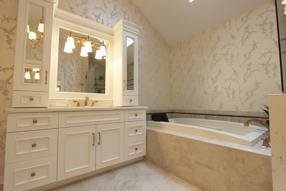 Aménagement d'une grande salle de bain principale classique avec un lavabo encastré, des portes de placard blanches, un plan de toilette en surface solide, une baignoire d'angle, une douche d'angle, un carrelage beige, des carreaux de porcelaine, un mur beige et un sol en carrelage de porcelaine.