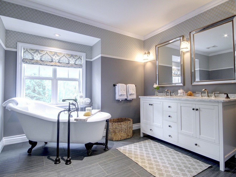 На фото: главная ванная комната среднего размера в классическом стиле с фасадами в стиле шейкер, белыми фасадами, ванной на ножках, серыми стенами, мраморной столешницей, полом из керамогранита, врезной раковиной и серым полом