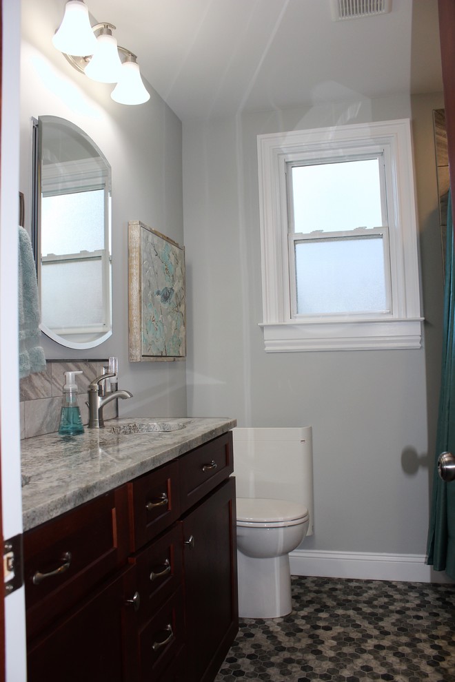 Design ideas for a medium sized traditional ensuite bathroom in Baltimore with recessed-panel cabinets, dark wood cabinets, a shower/bath combination, a one-piece toilet, black and white tiles, ceramic tiles, grey walls, ceramic flooring, a submerged sink and granite worktops.