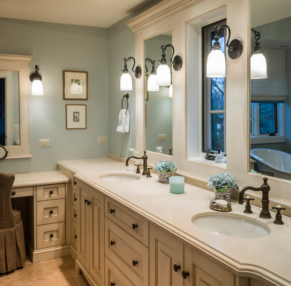 Large mountain style master marble floor claw-foot bathtub photo in Chicago with an undermount sink, raised-panel cabinets, white cabinets, limestone countertops and blue walls