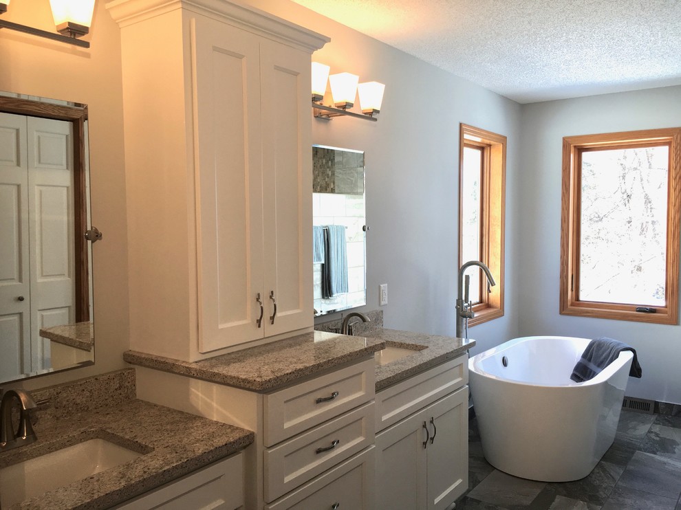 Photo of a medium sized contemporary ensuite bathroom in Minneapolis with recessed-panel cabinets, white cabinets, a freestanding bath, grey walls, a submerged sink, engineered stone worktops, multi-coloured floors and multi-coloured worktops.