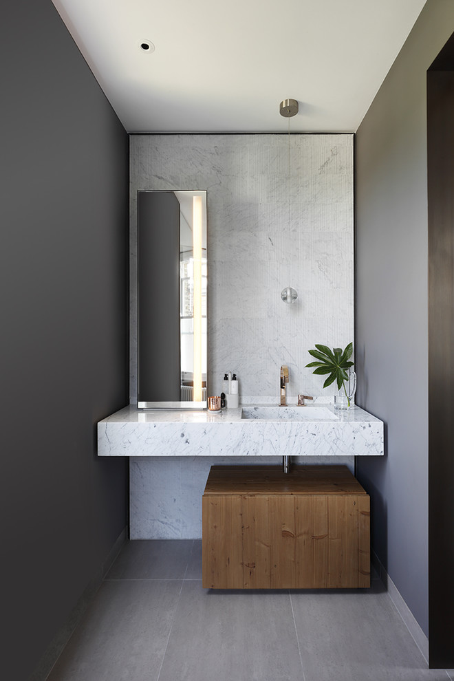 Foto de cuarto de baño contemporáneo de tamaño medio con paredes grises, lavabo suspendido y suelo gris
