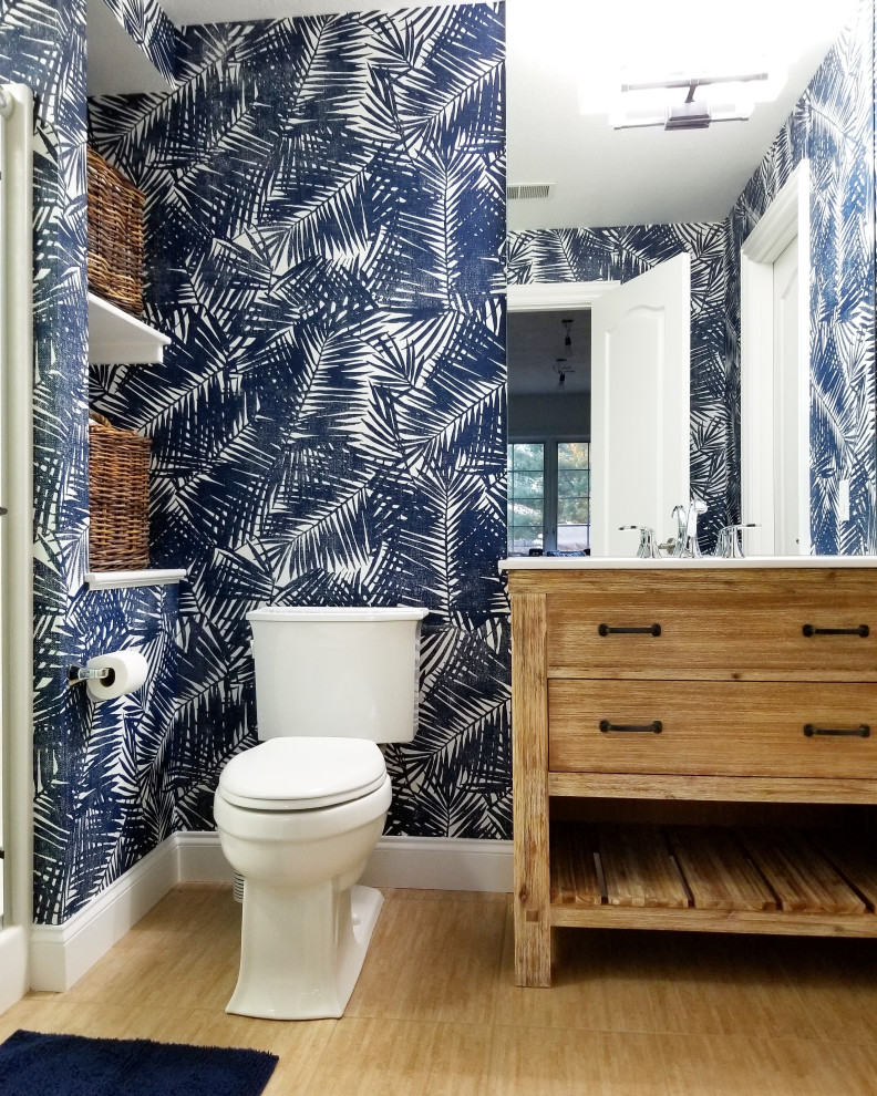 Inspiration for a tropical 3/4 medium tone wood floor and brown floor alcove shower remodel in Philadelphia with flat-panel cabinets, medium tone wood cabinets, a two-piece toilet, multicolored walls, an undermount sink and white countertops