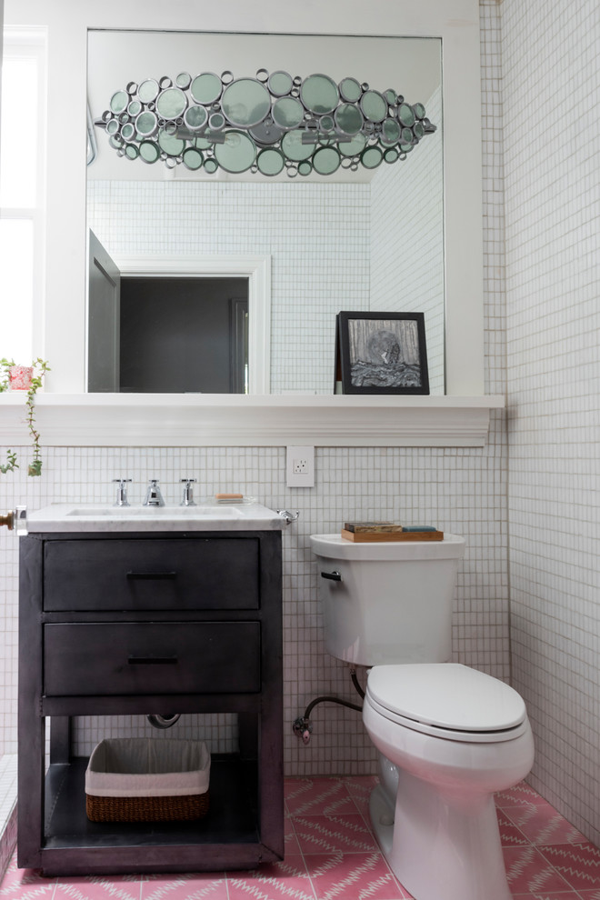 Idée de décoration pour une salle de bain tradition avec un placard à porte plane, des portes de placard noires, WC séparés, un carrelage blanc, mosaïque, un mur blanc, un lavabo encastré, un sol rose et un plan de toilette blanc.
