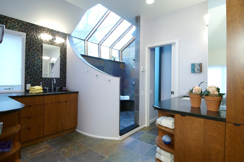 Пример оригинального дизайна: большая главная ванная комната в стиле модернизм с плоскими фасадами, фасадами цвета дерева среднего тона, открытым душем, белыми стенами, полом из сланца, врезной раковиной, столешницей из гранита, серым полом и открытым душем