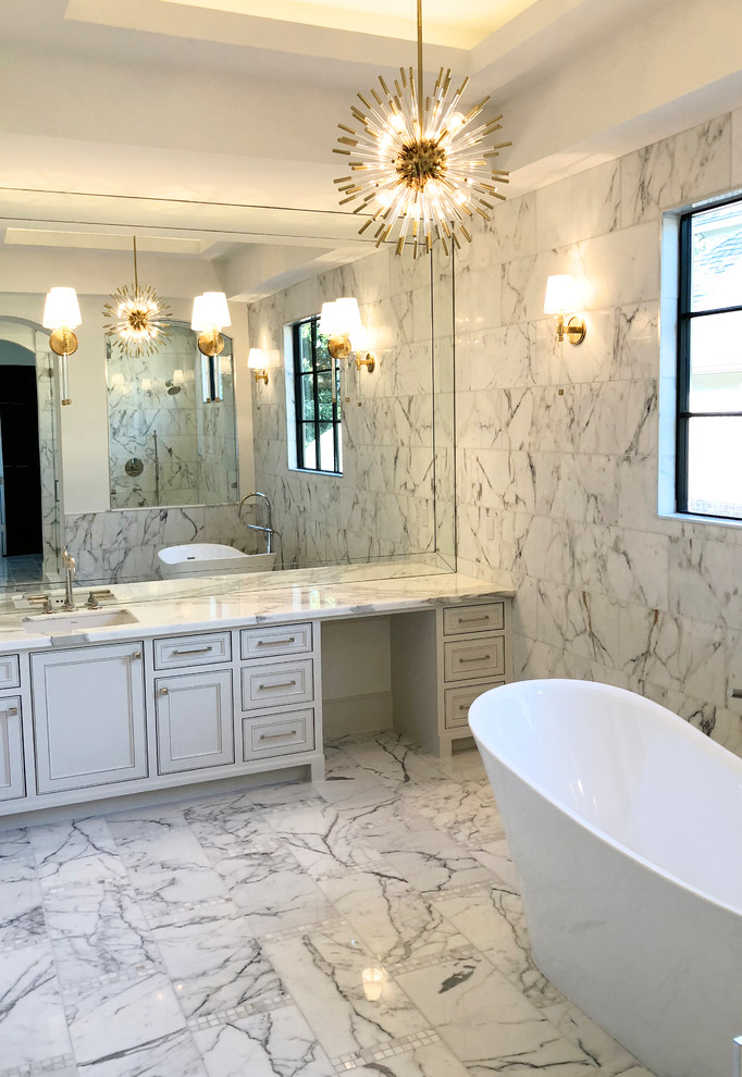Пример оригинального дизайна: огромная главная ванная комната в стиле модернизм с фасадами с декоративным кантом, белыми фасадами, отдельно стоящей ванной, двойным душем, раздельным унитазом, белой плиткой, мраморной плиткой, белыми стенами, мраморным полом, врезной раковиной, мраморной столешницей, белым полом, открытым душем и белой столешницей