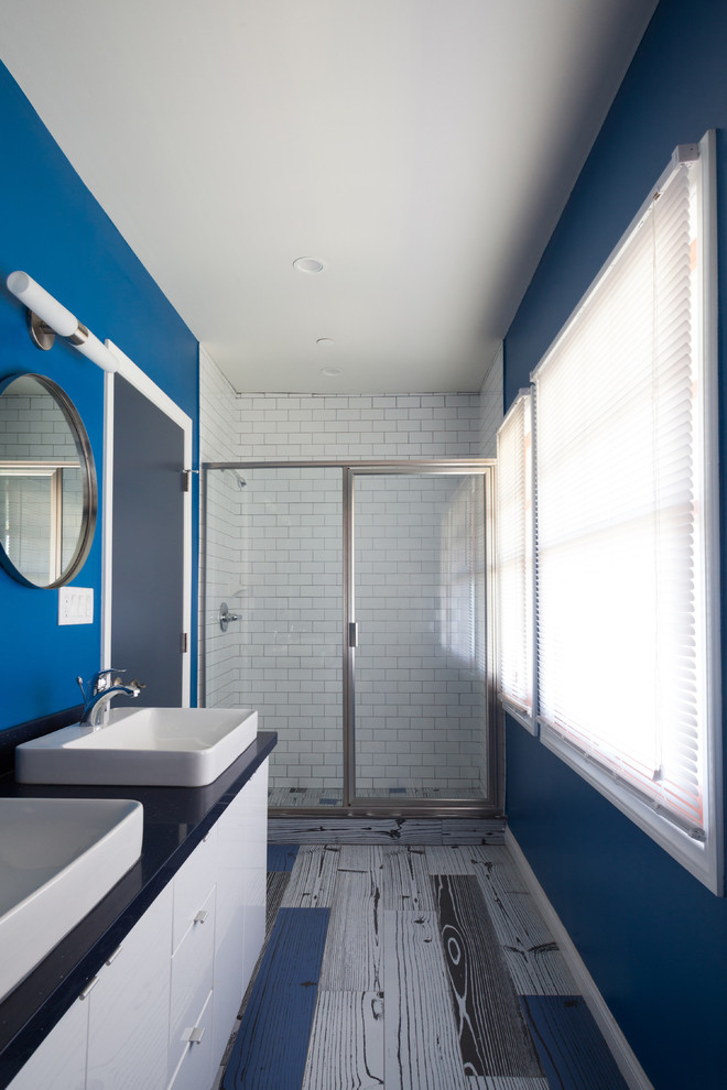Mid-sized minimalist 3/4 blue tile and porcelain tile porcelain tile alcove shower photo in Los Angeles with a vessel sink, flat-panel cabinets, white cabinets, quartz countertops and blue walls