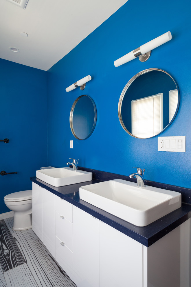 Immagine di una stanza da bagno con doccia minimalista di medie dimensioni con lavabo a bacinella, ante lisce, ante bianche, top in quarzo composito, doccia alcova, piastrelle blu, piastrelle in gres porcellanato, pareti blu e pavimento in gres porcellanato