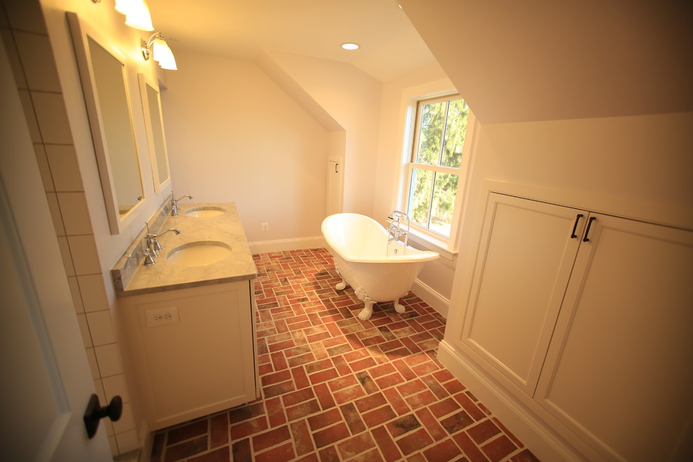 Réalisation d'une salle de bain principale avec un placard à porte shaker, des portes de placard blanches, une baignoire sur pieds, un carrelage blanc, des carreaux de béton, un mur blanc, un sol en brique, un lavabo encastré et un plan de toilette en granite.