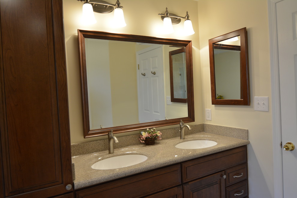 Cette photo montre une salle de bain principale chic en bois brun de taille moyenne avec un placard avec porte à panneau surélevé, un mur beige, un sol en carrelage de porcelaine, un lavabo encastré, un plan de toilette en granite, un sol beige et un plan de toilette multicolore.