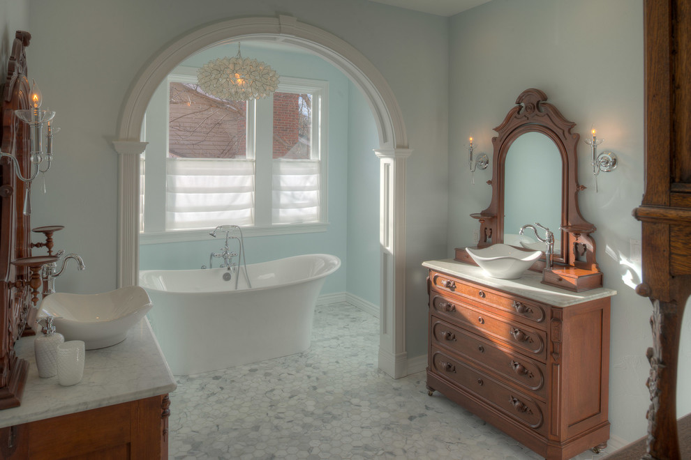 Inspiration pour une salle de bain principale traditionnelle en bois brun avec une vasque, un placard en trompe-l'oeil, un plan de toilette en marbre, une baignoire indépendante, une douche ouverte, WC à poser, un carrelage gris, un mur bleu et un sol en marbre.