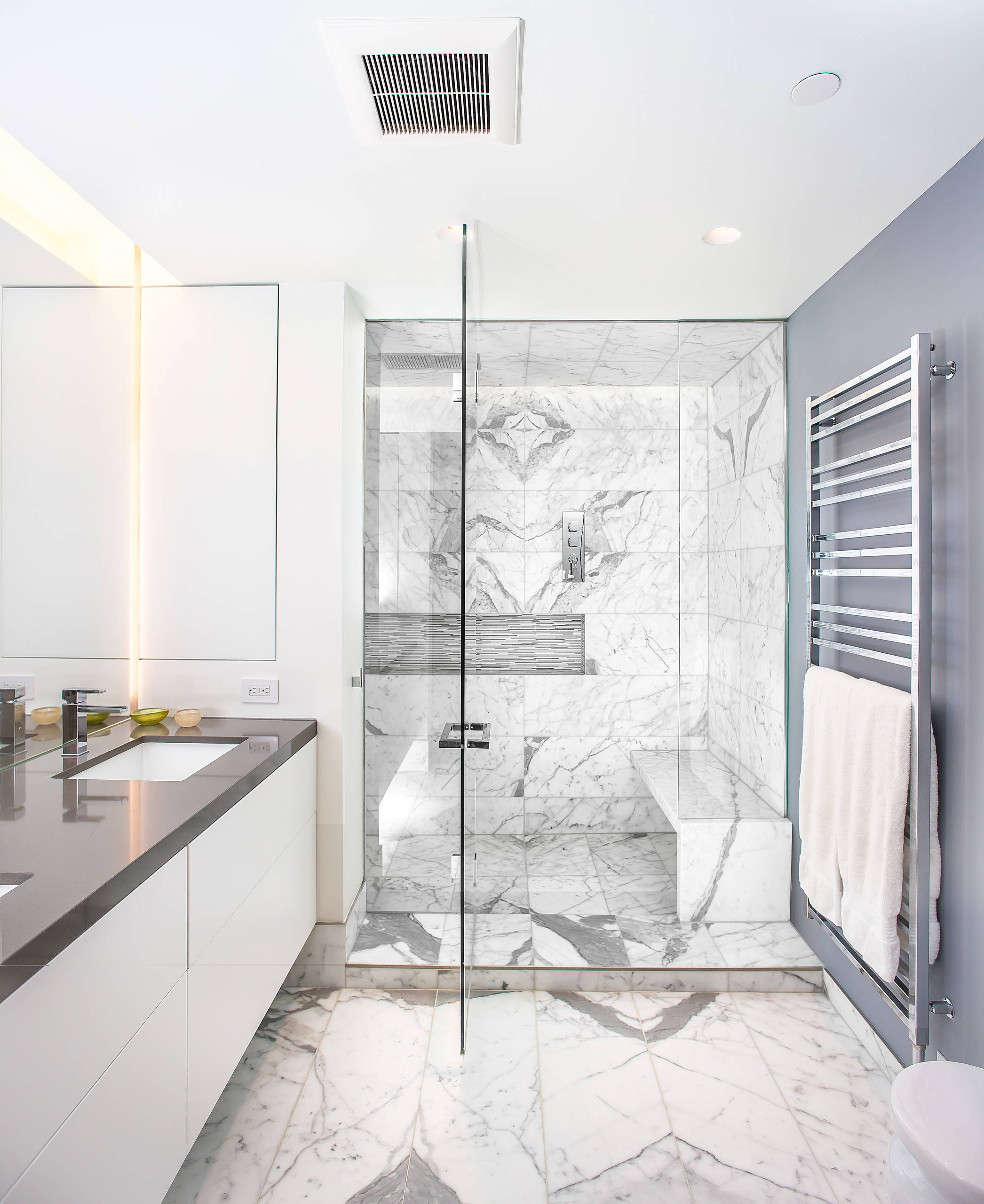 A luxury stand up grey marble shower with a rain shower head with