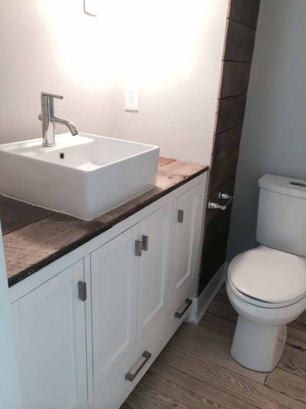 Medium sized farmhouse shower room bathroom in Baltimore with shaker cabinets, white cabinets, a two-piece toilet, white walls, medium hardwood flooring, a vessel sink and wooden worktops.