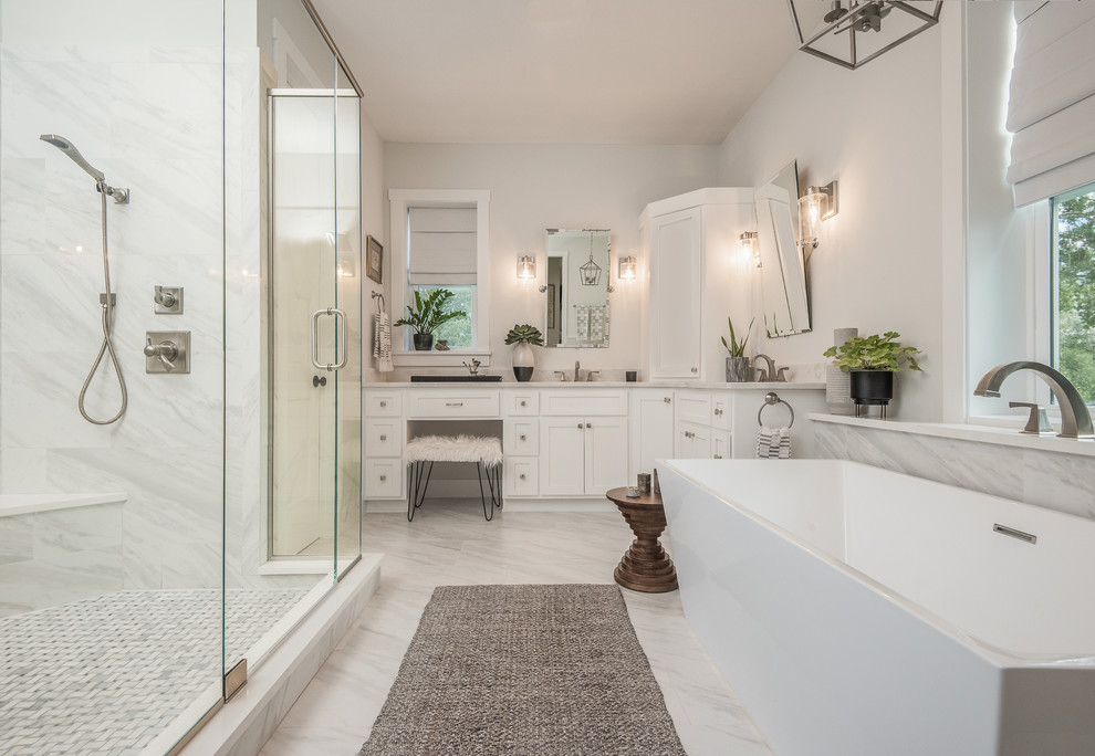 Foto de cuarto de baño costero con armarios estilo shaker, puertas de armario blancas, bañera exenta, paredes blancas, suelo blanco y encimeras beige