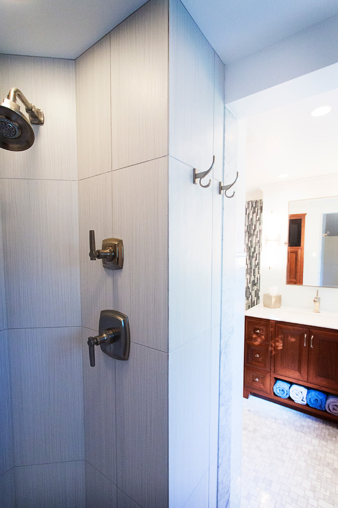 Пример оригинального дизайна: ванная комната в стиле неоклассика (современная классика) с врезной раковиной, фасадами островного типа, темными деревянными фасадами, мраморной столешницей, душем в нише, раздельным унитазом, серой плиткой, стеклянной плиткой, белыми стенами и мраморным полом
