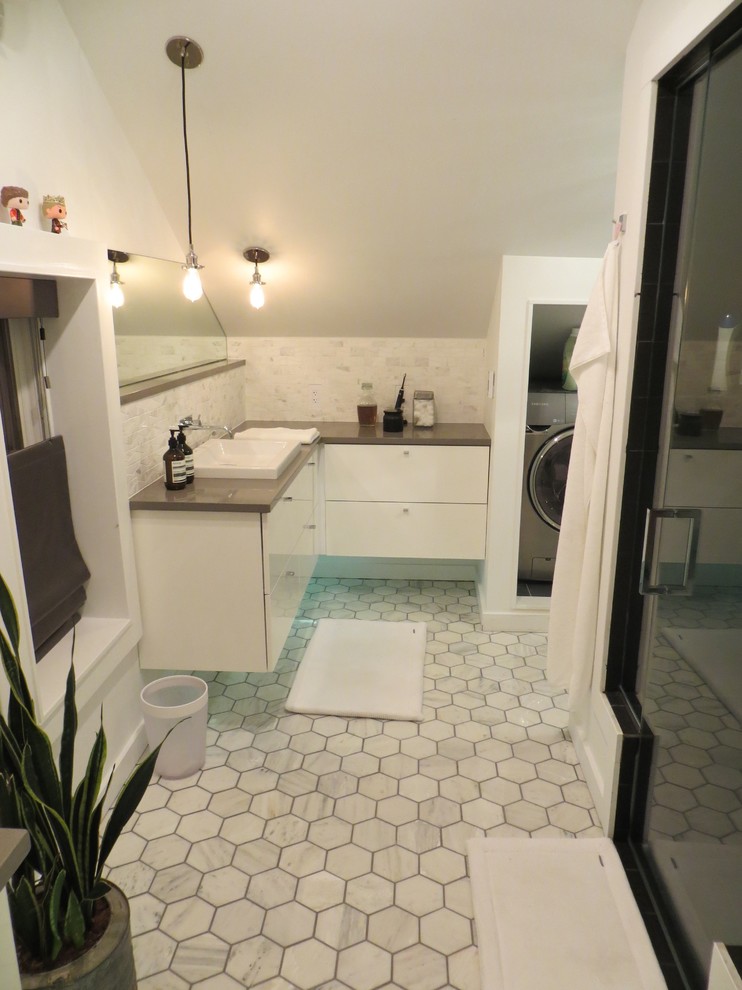 Réalisation d'une petite salle de bain design avec un lavabo posé, un placard à porte plane, des portes de placard blanches, un plan de toilette en surface solide, un carrelage blanc, un carrelage de pierre, un mur blanc et un sol en marbre.