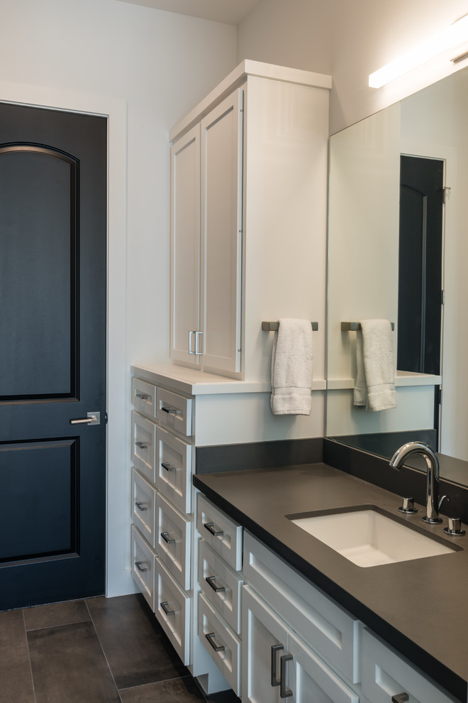 Example of a mid-sized trendy kids' gray tile and porcelain tile porcelain tile bathroom design in Houston with an undermount sink, recessed-panel cabinets, white cabinets, solid surface countertops and white walls