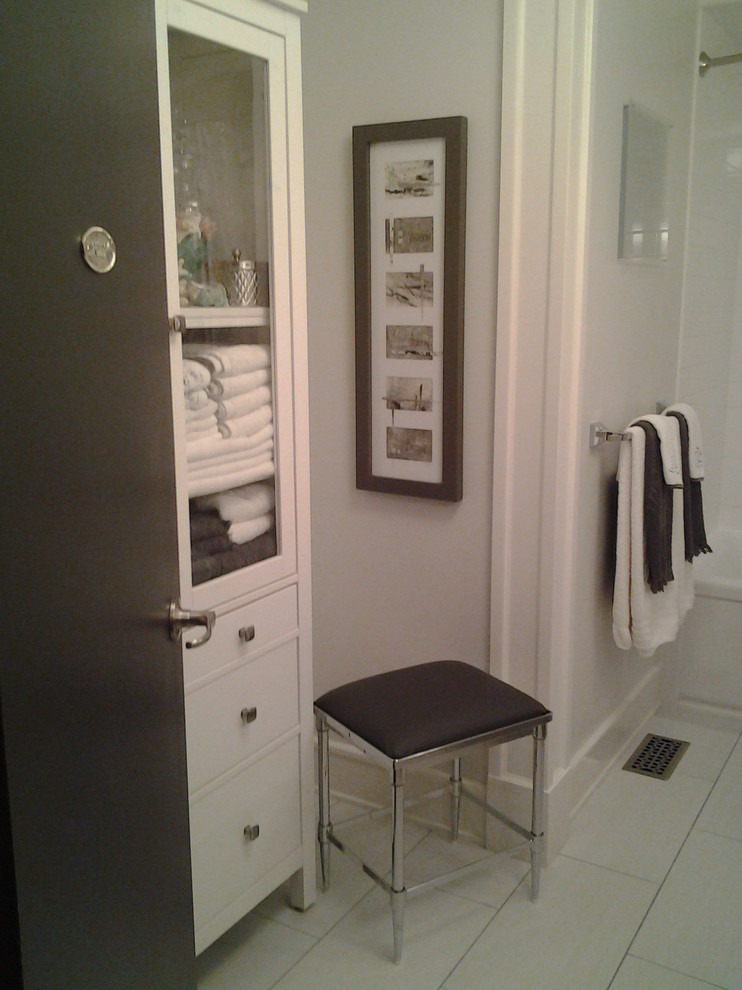 Cette photo montre une petite salle de bain tendance avec une vasque, un placard à porte plane, des portes de placard blanches, un plan de toilette en stratifié, une baignoire en alcôve, un combiné douche/baignoire, WC à poser, un carrelage blanc, un carrelage de pierre, un mur gris et un sol en carrelage de porcelaine.