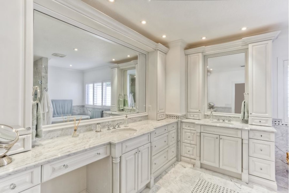 Foto på ett stort vintage en-suite badrum, med luckor med upphöjd panel, vita skåp, ett fristående badkar, en dusch i en alkov, vit kakel, porslinskakel, vita väggar, marmorgolv, ett undermonterad handfat och marmorbänkskiva