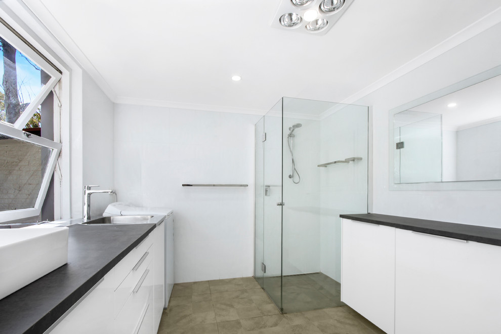 Inspiration för ett mellanstort funkis badrum, med möbel-liknande, vita skåp, en kantlös dusch, vit kakel, porslinskakel, vita väggar, klinkergolv i keramik, beiget golv och dusch med gångjärnsdörr