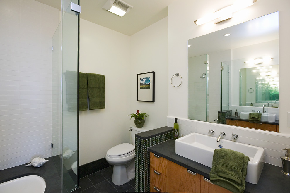 Tub/shower combo - contemporary white tile tub/shower combo idea in San Francisco with a vessel sink, flat-panel cabinets, medium tone wood cabinets, an undermount tub and a two-piece toilet