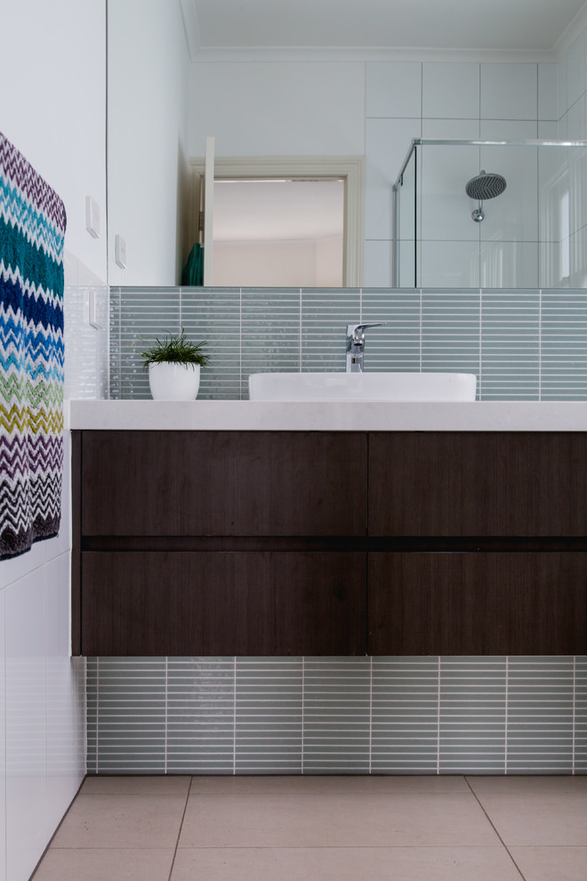 Стильный дизайн: главная ванная комната среднего размера в стиле модернизм с темными деревянными фасадами, синей плиткой, стеклянной плиткой, белыми стенами и душем с распашными дверями - последний тренд