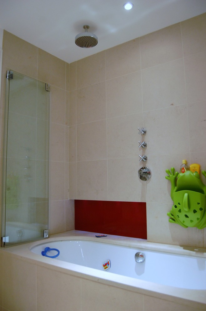 Inspiration för ett mellanstort funkis badrum för barn, med ett väggmonterat handfat, luckor med profilerade fronter, träbänkskiva, ett platsbyggt badkar, en dusch/badkar-kombination, en vägghängd toalettstol, beige kakel, stenhäll, vita väggar och kalkstensgolv