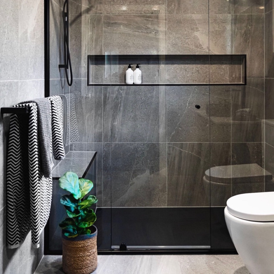 Esempio di una stanza da bagno con doccia industriale di medie dimensioni con doccia alcova, piastrelle grigie, piastrelle in gres porcellanato, pareti grigie, pavimento in gres porcellanato, pavimento grigio e porta doccia a battente