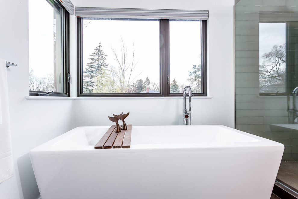 Diseño de cuarto de baño contemporáneo con bañera exenta y paredes blancas