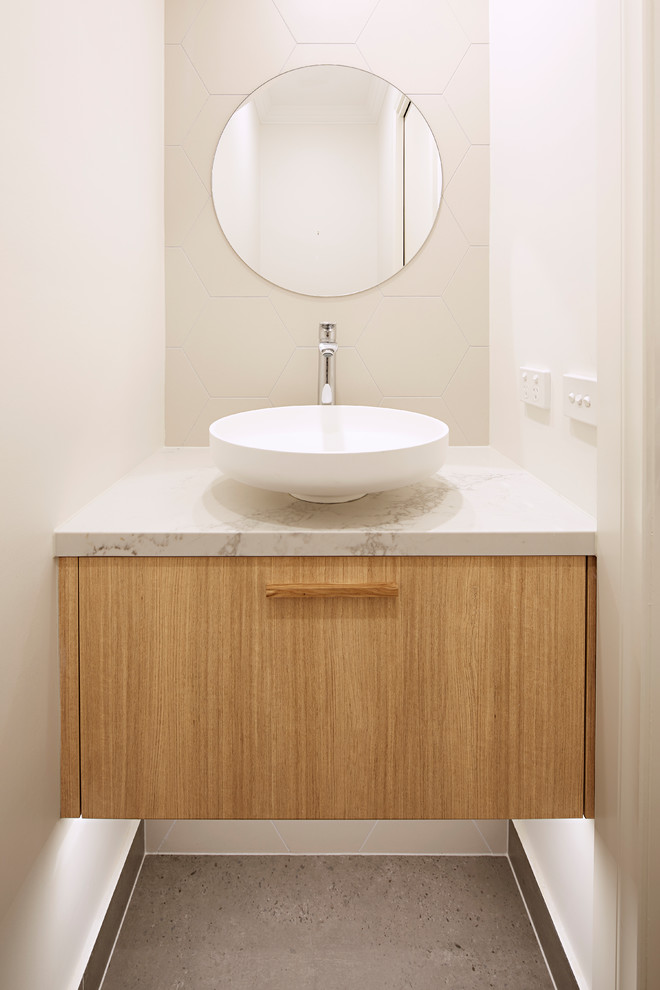 Example of a mid-sized beach style master multicolored tile and stone slab bathroom design in Melbourne with beaded inset cabinets, light wood cabinets, a wall-mount toilet, multicolored walls, a vessel sink, marble countertops and white countertops