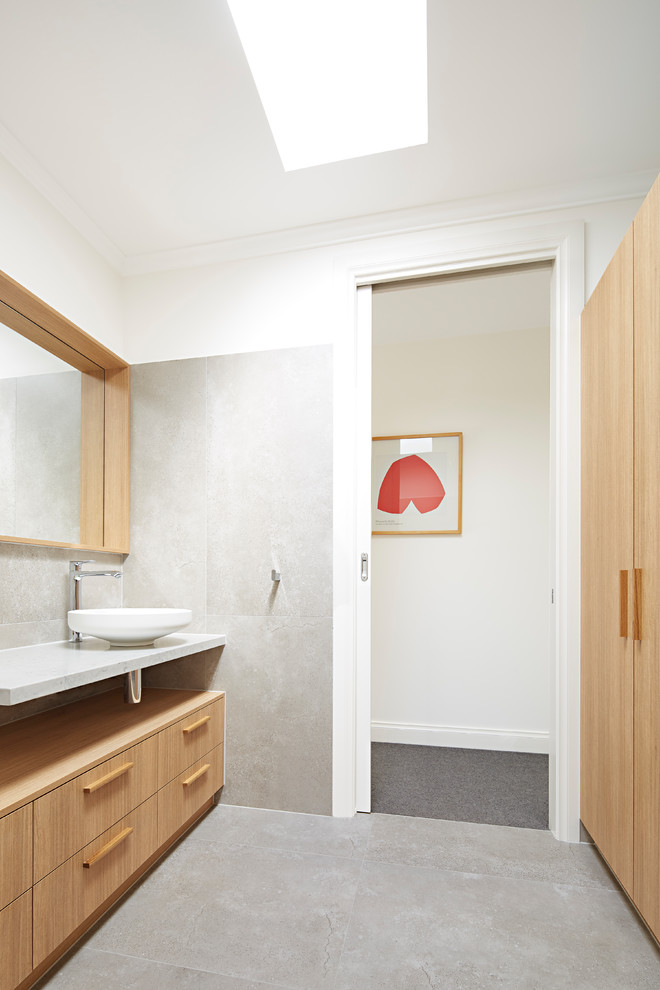 Bathroom - mid-sized coastal master multicolored tile and stone slab bathroom idea in Melbourne with beaded inset cabinets, light wood cabinets, a wall-mount toilet, multicolored walls, a vessel sink, marble countertops and white countertops