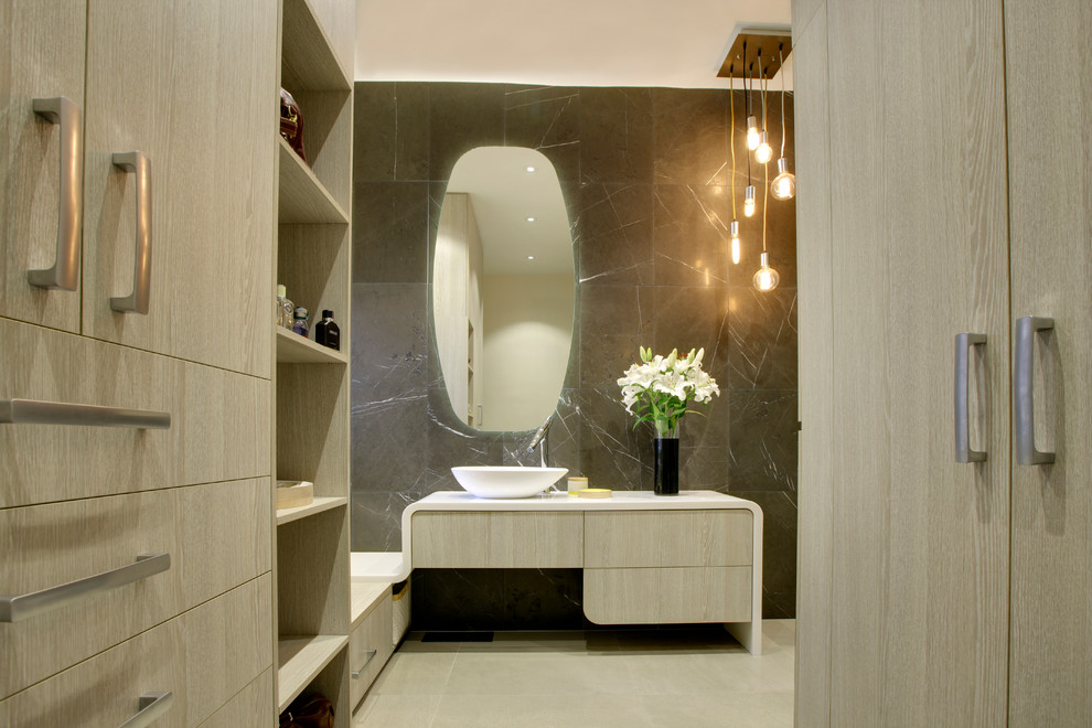 Design ideas for a medium sized contemporary ensuite bathroom in Melbourne with a vessel sink, freestanding cabinets, light wood cabinets, solid surface worktops, a freestanding bath, a walk-in shower, grey tiles, stone tiles, grey walls and limestone flooring.