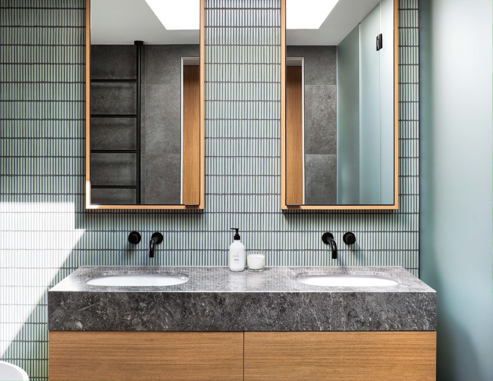 Inspiration for a medium sized contemporary ensuite bathroom in Melbourne with flat-panel cabinets, white cabinets, a built-in bath, a corner shower, a two-piece toilet, black and white tiles, grey tiles, ceramic tiles, grey walls, ceramic flooring, a built-in sink, engineered stone worktops, grey floors, a hinged door and white worktops.