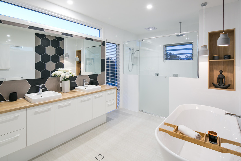 Inredning av ett minimalistiskt stort en-suite badrum, med ett fristående badkar, en dubbeldusch, flerfärgad kakel, flerfärgade väggar, klinkergolv i porslin, ett nedsänkt handfat, laminatbänkskiva, dusch med gångjärnsdörr, porslinskakel och vitt golv