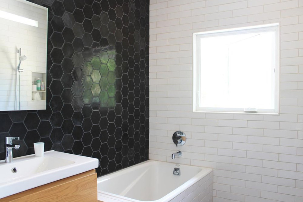 Ispirazione per una stanza da bagno con doccia moderna di medie dimensioni con vasca giapponese, pareti nere e lavabo integrato