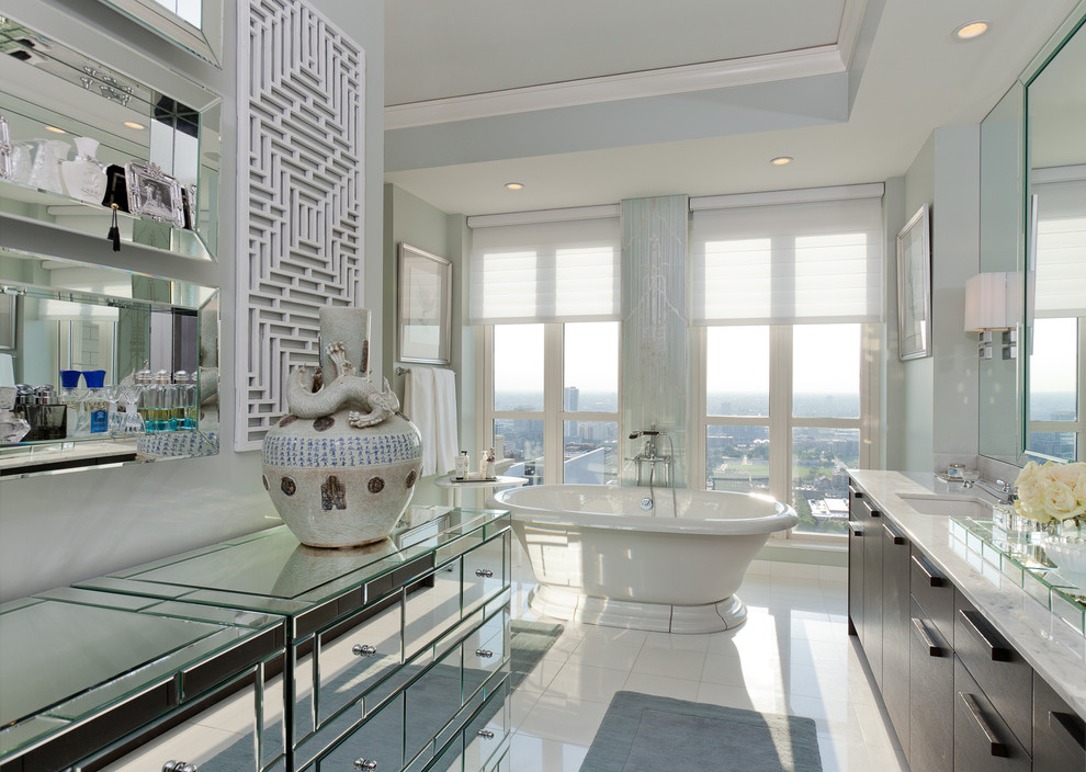 Пример оригинального дизайна: ванная комната в современном стиле с врезной раковиной, плоскими фасадами, отдельно стоящей ванной и белыми стенами