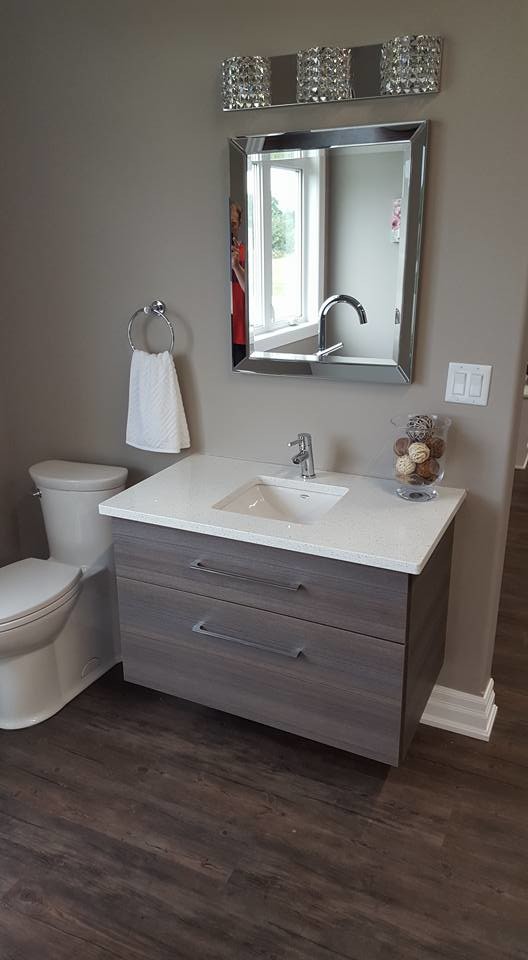Idéer för ett litet modernt badrum med dusch, med släta luckor, grå skåp, en toalettstol med hel cisternkåpa, grå kakel, grå väggar, klinkergolv i porslin, ett undermonterad handfat, bänkskiva i kvarts och brunt golv