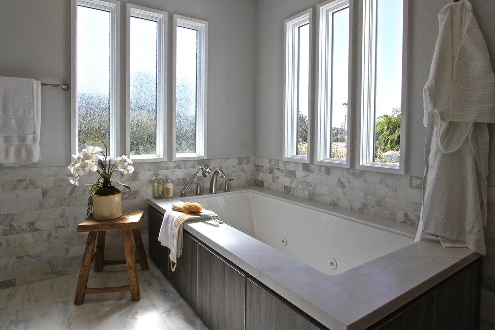Idéer för ett mellanstort klassiskt en-suite badrum, med släta luckor, grå skåp, ett platsbyggt badkar, en toalettstol med separat cisternkåpa, grå kakel, vit kakel, tunnelbanekakel, grå väggar, marmorgolv, ett undermonterad handfat och marmorbänkskiva