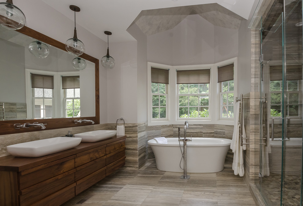 Exemple d'une grande salle de bain principale chic avec un mur gris, parquet foncé, une vasque, un plan de toilette en terrazzo, une baignoire indépendante, une douche double, un carrelage gris et un carrelage de pierre.