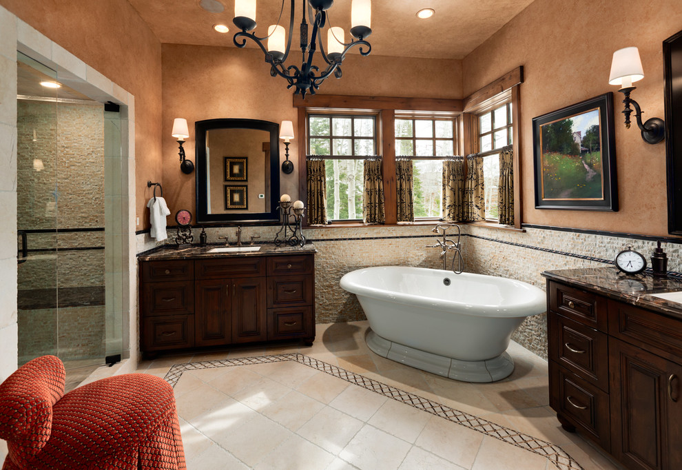Idées déco pour une grande salle de bain principale craftsman en bois foncé avec un placard avec porte à panneau surélevé, une baignoire indépendante, une douche ouverte, un carrelage de pierre, un mur orange, un sol en carrelage de céramique, un lavabo encastré, un plan de toilette en granite et un carrelage beige.