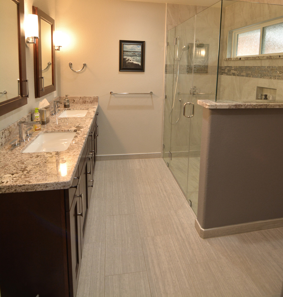 Modernes Badezimmer mit hellbraunen Holzschränken, Eckdusche, beigen Fliesen, Porzellanfliesen, beiger Wandfarbe, Porzellan-Bodenfliesen, beigem Boden, Falttür-Duschabtrennung und beiger Waschtischplatte in Las Vegas