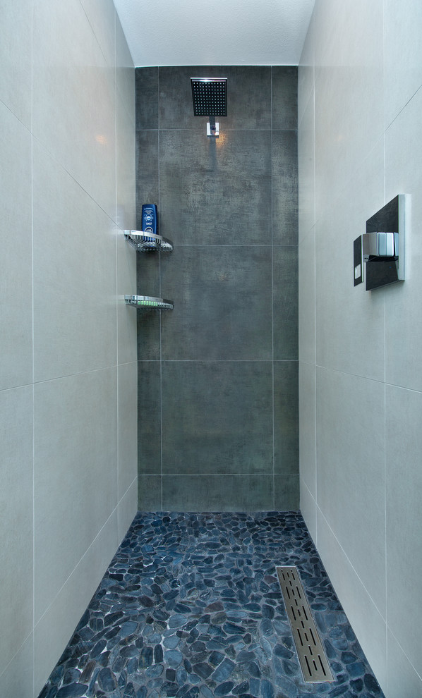 На фото: главная ванная комната среднего размера в современном стиле с плоскими фасадами, черными фасадами, душем в нише, раздельным унитазом, серой плиткой, керамической плиткой, серыми стенами, полом из галечной плитки, врезной раковиной, столешницей из искусственного кварца, синим полом, открытым душем и белой столешницей с