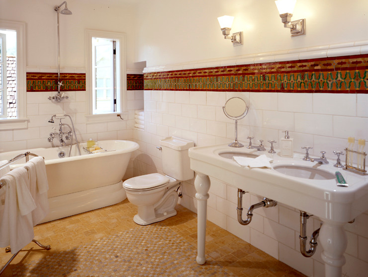 Foto på ett stort medelhavsstil en-suite badrum, med ett piedestal handfat, ett fristående badkar, en toalettstol med separat cisternkåpa, vit kakel, keramikplattor, vita väggar och travertin golv