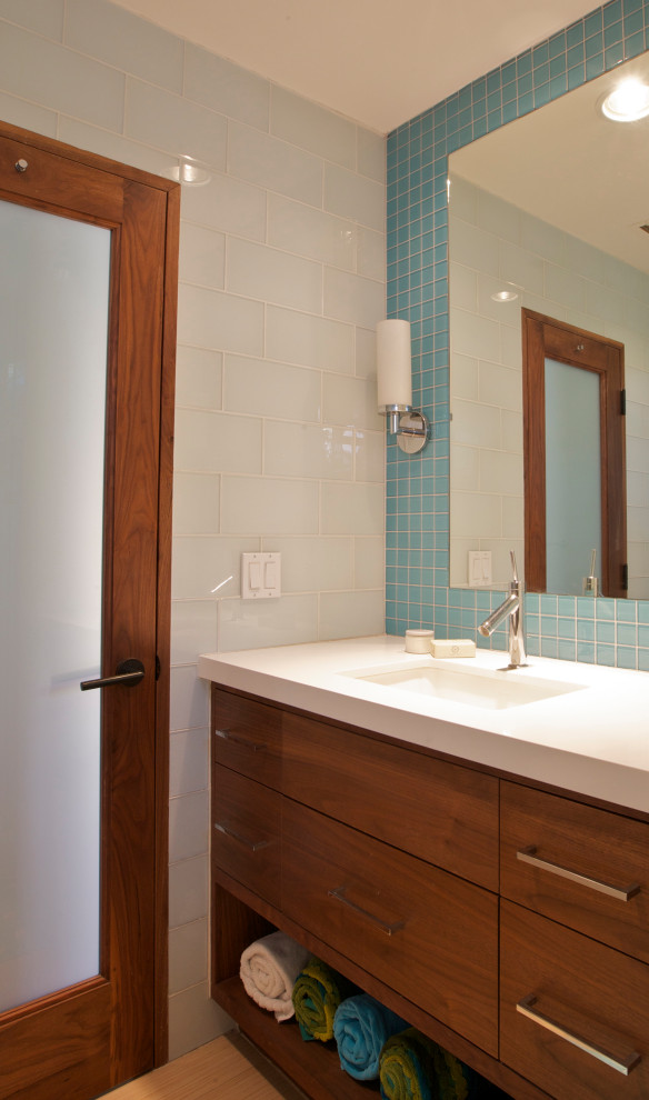 Foto på ett mellanstort funkis vit badrum med dusch, med släta luckor, skåp i mellenmörkt trä, en dusch i en alkov, blå kakel, glaskakel, klinkergolv i keramik, ett undermonterad handfat, bänkskiva i kvarts, beiget golv och dusch med gångjärnsdörr