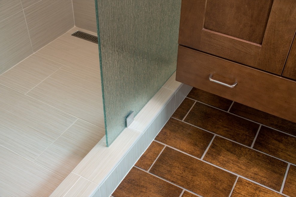 Photo of a traditional bathroom in San Diego with recessed-panel cabinets, medium wood cabinets, an alcove shower, brown tiles and stone tiles.