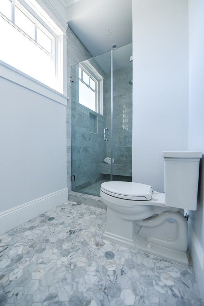 Photo of a large nautical shower room bathroom in Los Angeles with shaker cabinets, grey cabinets, an alcove shower, a one-piece toilet, grey tiles, stone tiles, blue walls, mosaic tile flooring, a submerged sink and marble worktops.