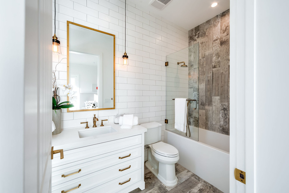 Foto på ett vintage vit badrum med dusch, med luckor med infälld panel, vita skåp, ett hörnbadkar, en dusch/badkar-kombination, brun kakel, grå kakel, vit kakel, vita väggar, ett undermonterad handfat, grått golv och med dusch som är öppen