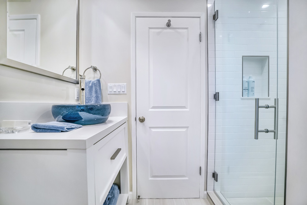 Exemple d'une petite salle de bain rétro avec un placard avec porte à panneau encastré, des portes de placard beiges, WC à poser, un carrelage blanc, des carreaux de céramique, un mur beige, un sol en carrelage de porcelaine, une vasque, un plan de toilette en quartz modifié, un sol gris et une cabine de douche à porte battante.