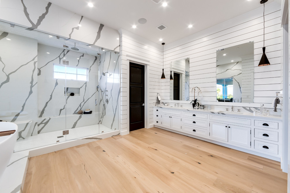Design ideas for a large classic ensuite bathroom in Los Angeles with shaker cabinets, white cabinets, a claw-foot bath, white tiles, marble tiles, white walls, light hardwood flooring, a built-in sink, marble worktops, brown floors, a hinged door, multi-coloured worktops, an alcove shower and a one-piece toilet.